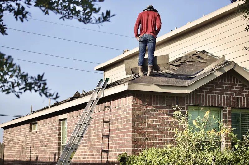 Professional roofer working on a residential roof in West River